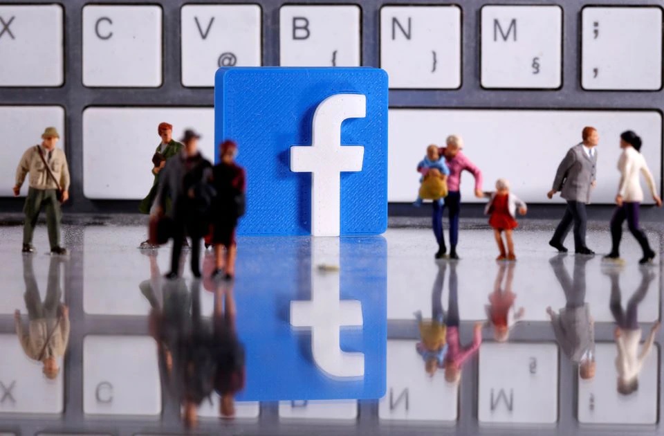 Logo Facebook cetak 3D ditempatkan di antara figur orang mainan kecil di depan keyboard dalam ilustrasi ini diambil 12 April 2020. Foto: Reuters.