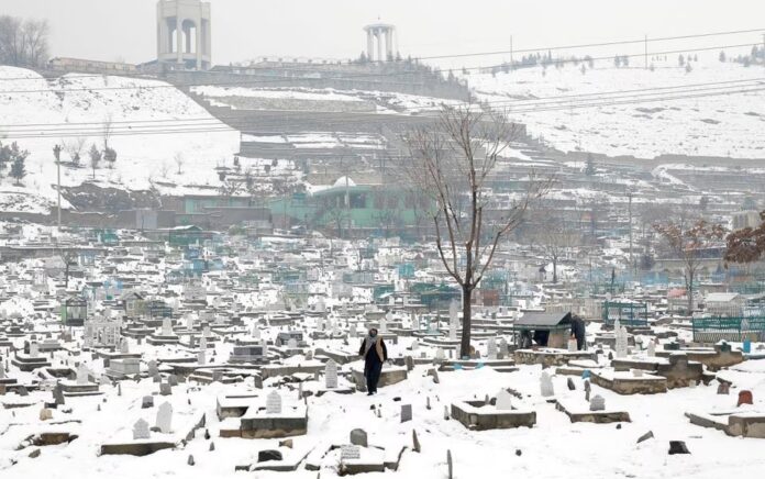 Seorang pria Afghanistan berjalan di pemakaman yang tertutup salju di Kabul, Afghanistan, 11 Januari 2023. Foto: Reuters/Ali Khara/Foto file.