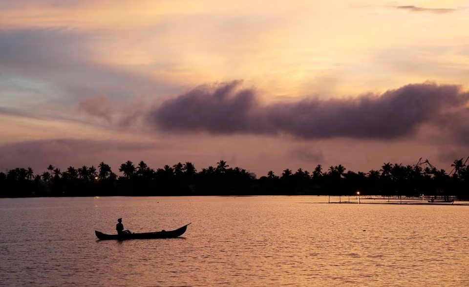 Seorang pria mendayung perahunya di perairan anak sungai Danau Vembanad dengan latar belakang awan pra-musim di pinggiran Kochi, India, 7 Juni 2019. Foto: Reuters/Sivaram V/File Foto.