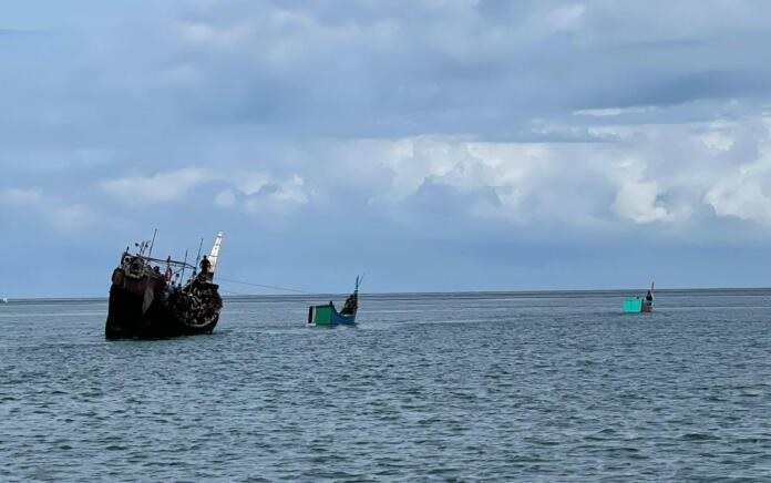 Dua boat kecil milik warga menarik perahu etnis Rohingya ke laut saat ingin mendarat di tepi pantai Gampong Pulo Pineung Meunasah Dua, Kecamatan Jangka, Kabupaten Bireuen, Provinsi Aceh, Kamis (16/11) dini hari sekira pukul 04.30 WIB.